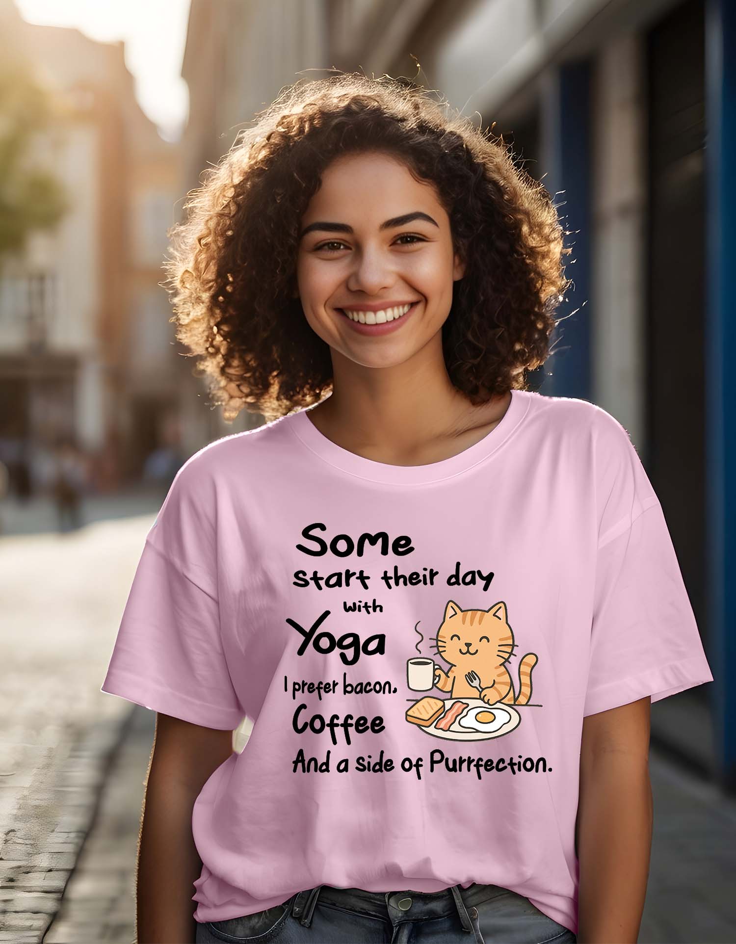 Person wearing a Dumkee Oversize pink t-shirt with a cat graphic and text on a city street.