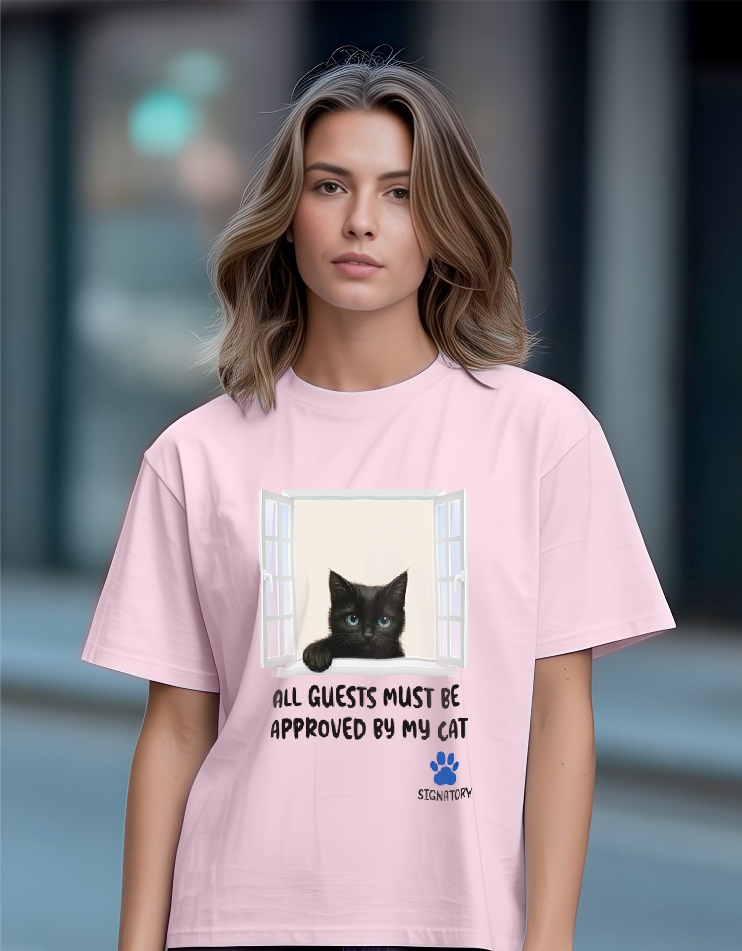 Woman wearing a Dumkee pink oversize t-shirt with a cat graphic and text.