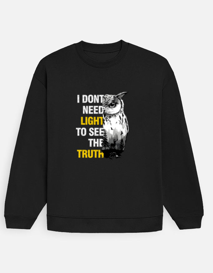 Man wearing a black Dumkee sweatshirt with an owl graphic and text on a blurred street background