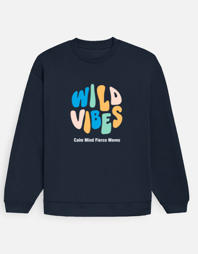 Man wearing a Dumkee Oversize navy blue sweatshirt with 'Wild Vibes' text in colorful letters.