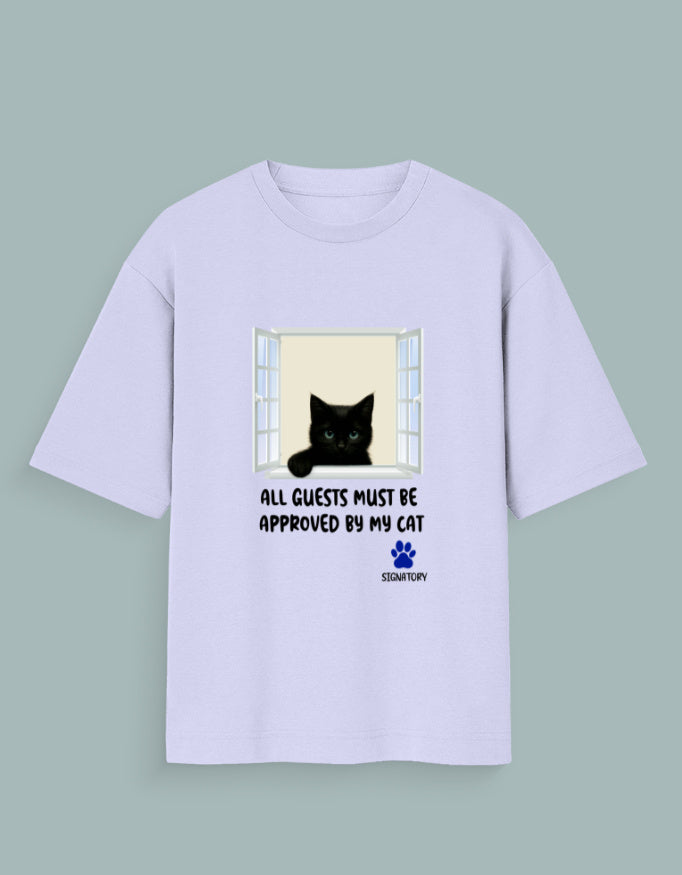 Person wearing a Dumkee white oversize t-shirt with a black cat graphic and text in an urban setting