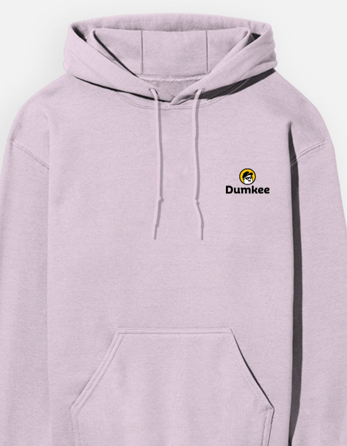 Person wearing a Dumkee baby pink hoodie with a logo, sitting on a gray floor.