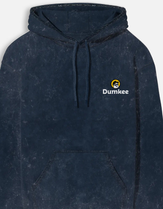 Man wearing a Dumkee Oversize dark blue hoodie with a logo on a gray background