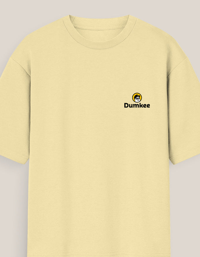 Person wearing a Dumkee Oversize light yellow t-shirt with a logo