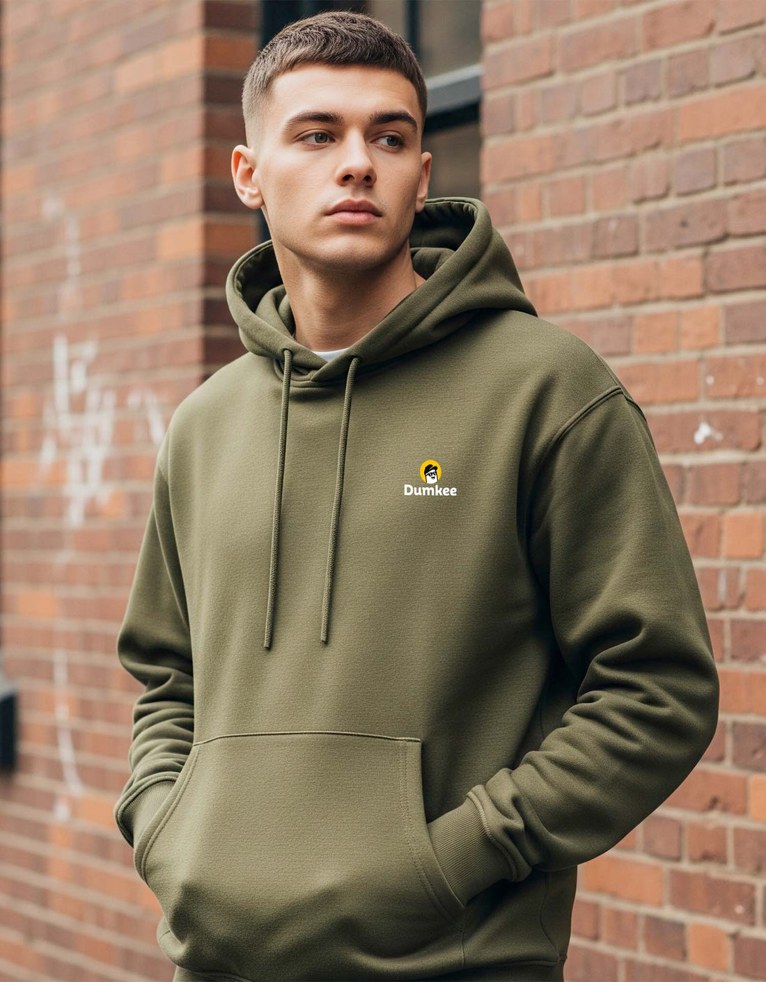 Man wearing a Dumkee Oversize olive green hoodie with a logo