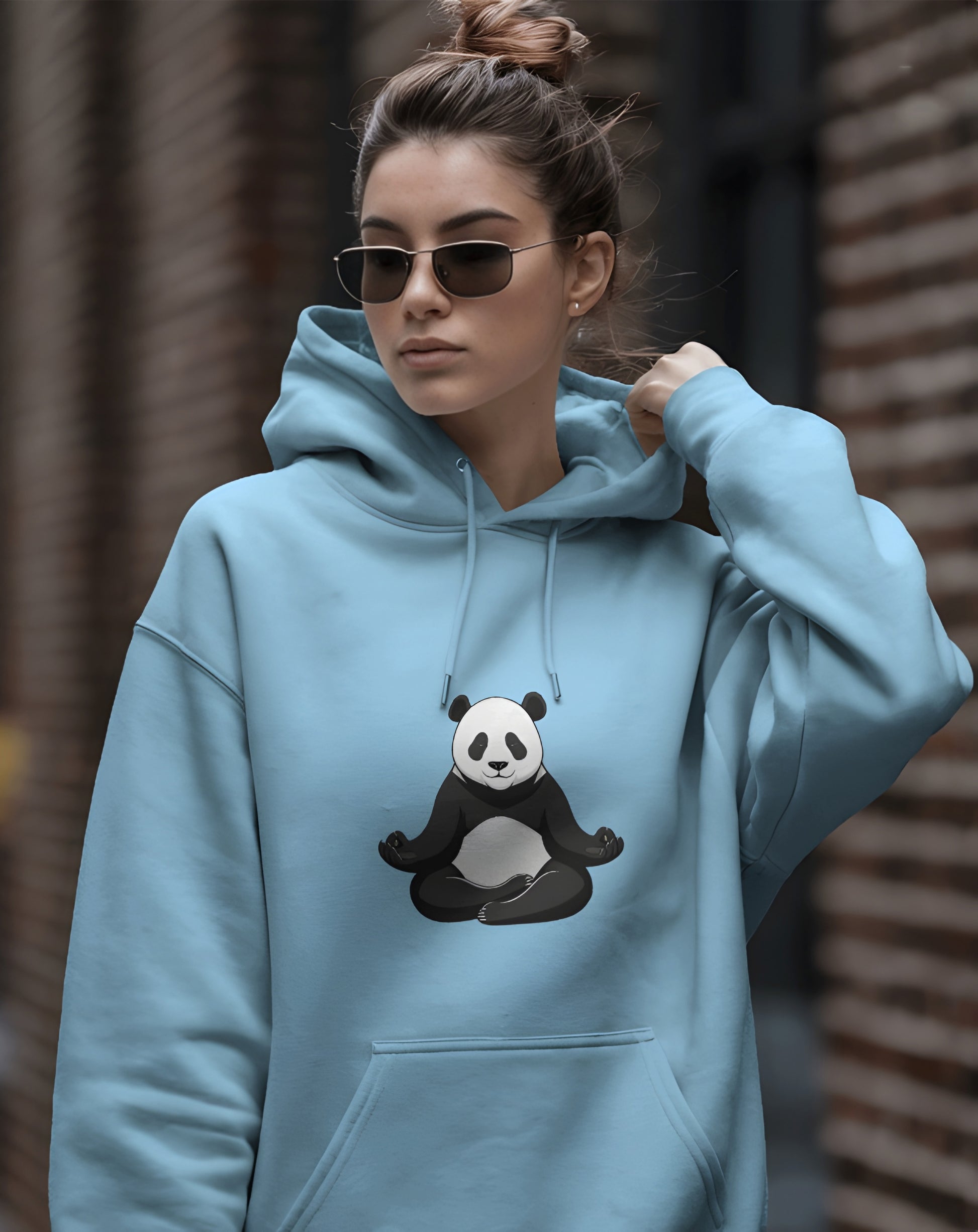 Person wearing a Dumkee light blue hoodie with a panda design.