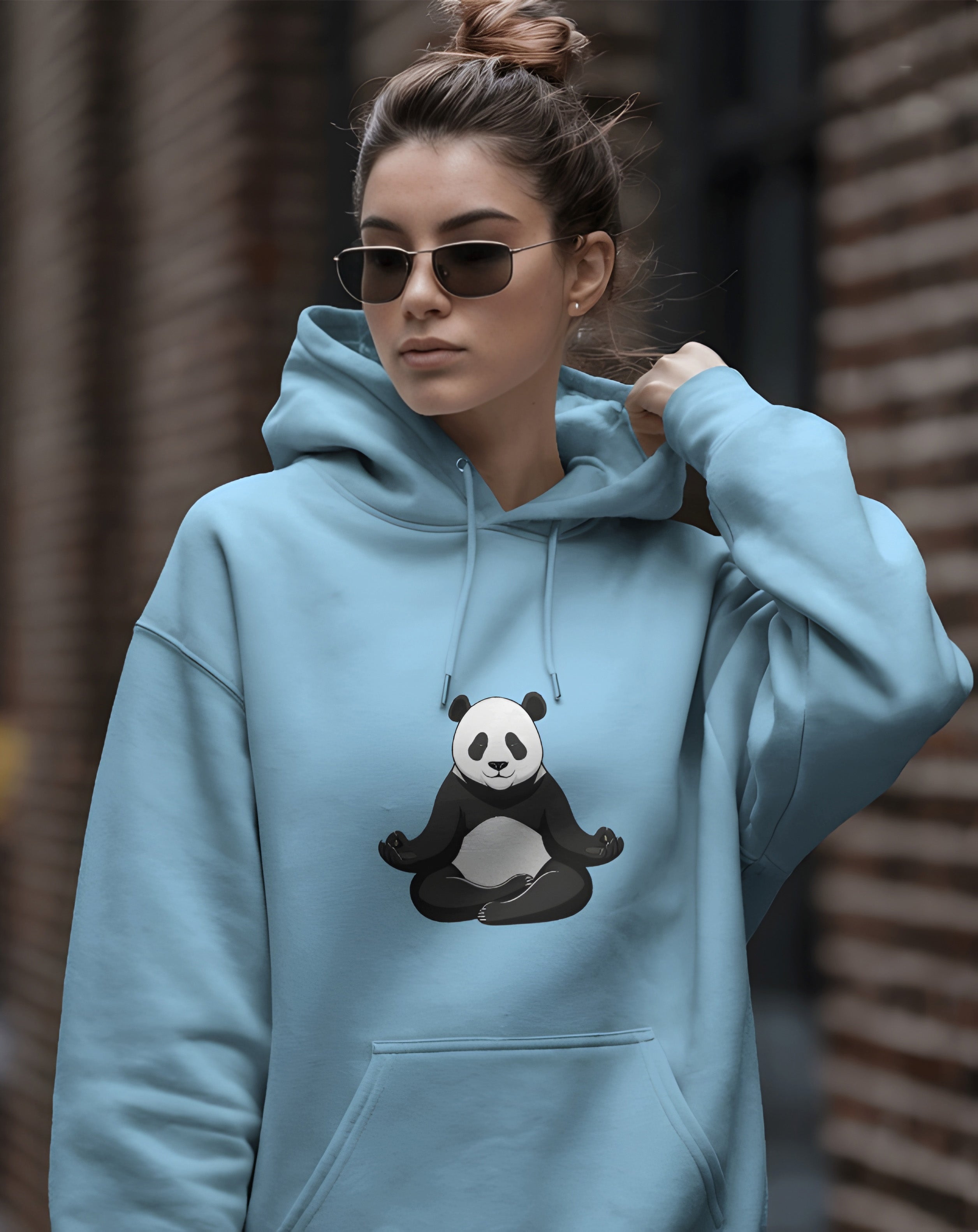 Person wearing a Dumkee light blue hoodie with a panda design.