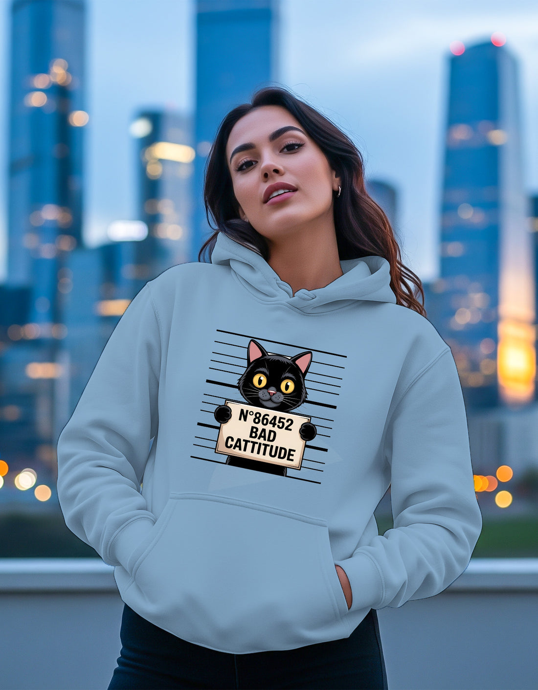 Woman wearing a Dumkee light blue hoodie with a cat graphic and text
