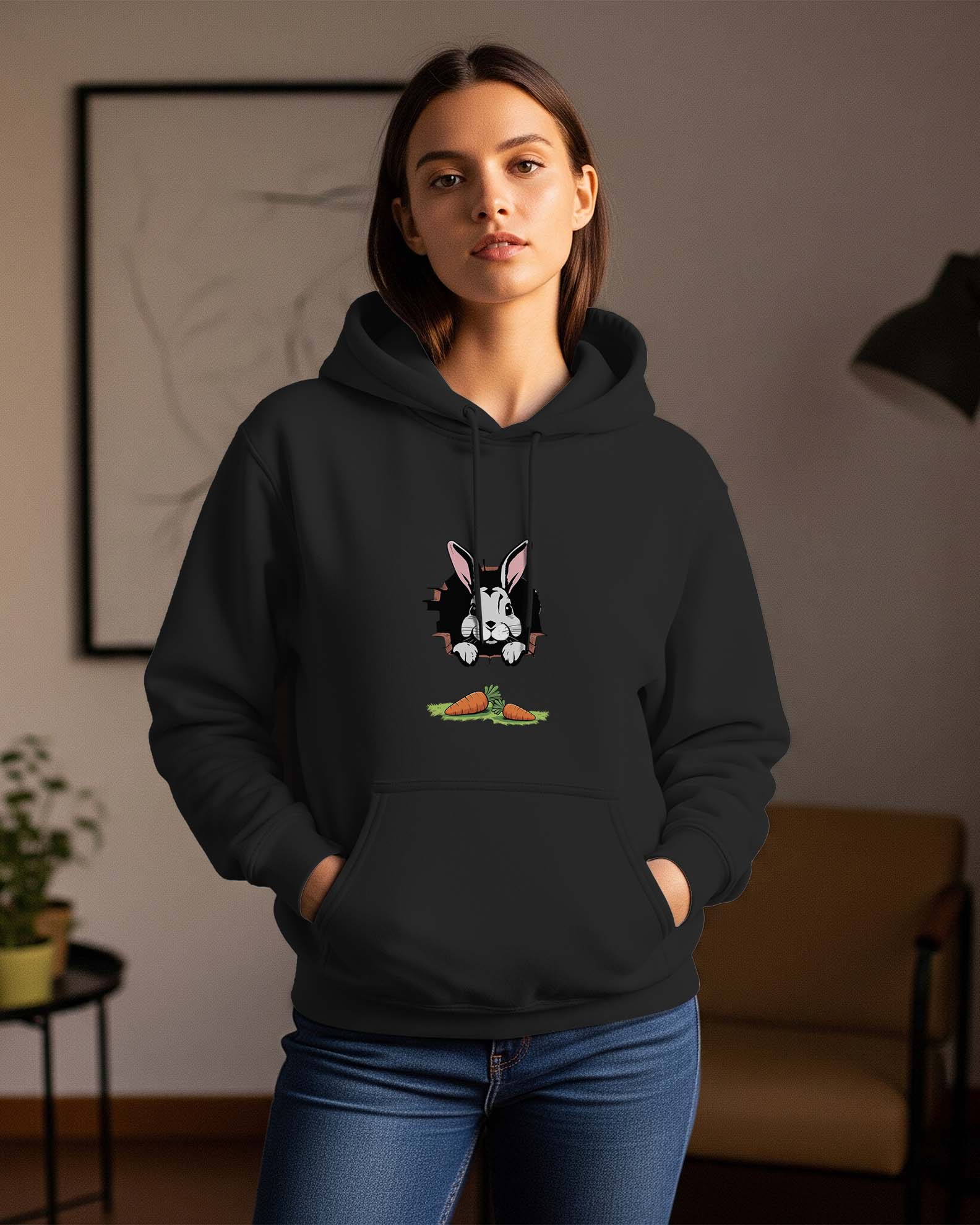 Woman wearing a Dumkee black regular fit hoodie with a rabbit graphic in a room.