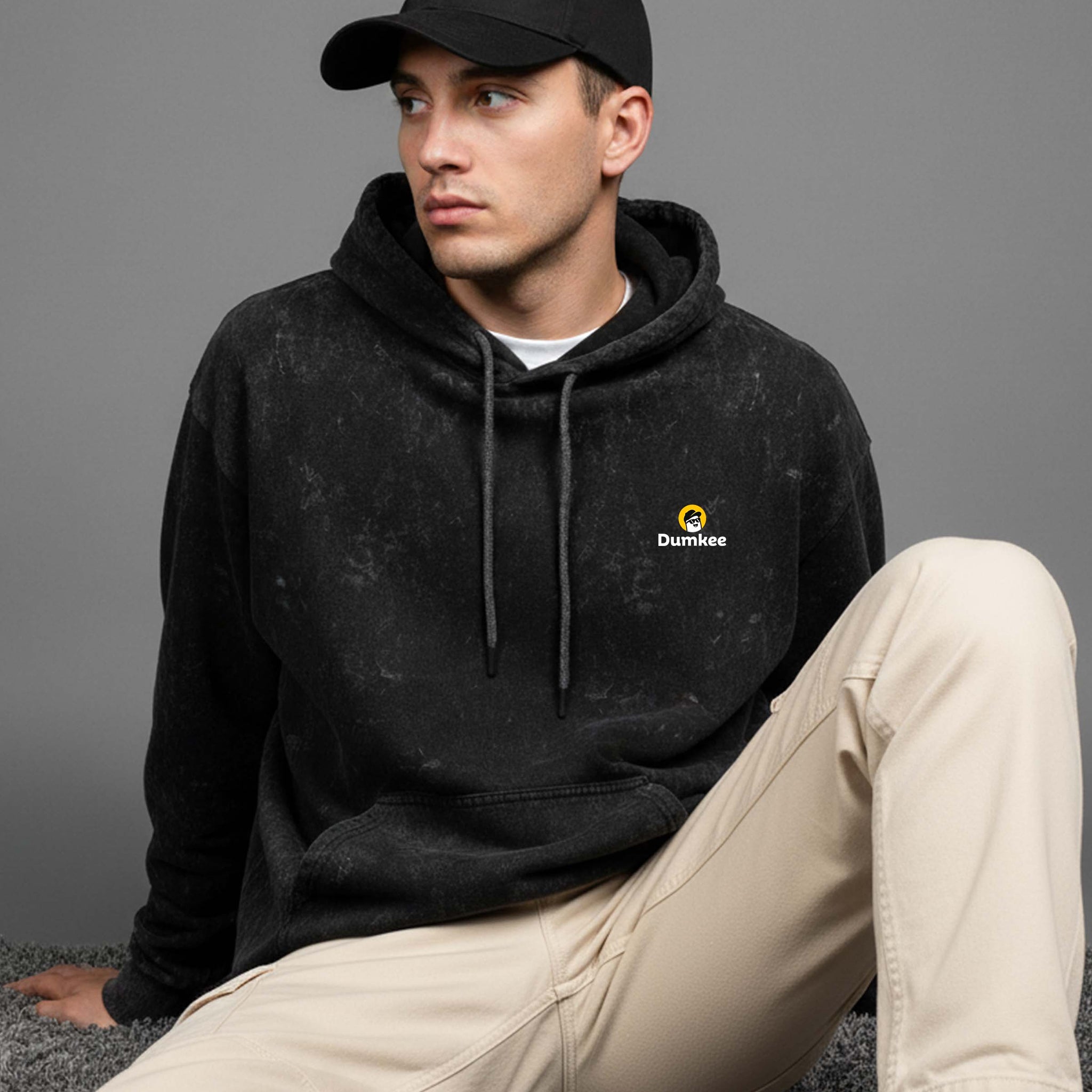 Man wearing a Dumkee Oversize black hoodie with a logo