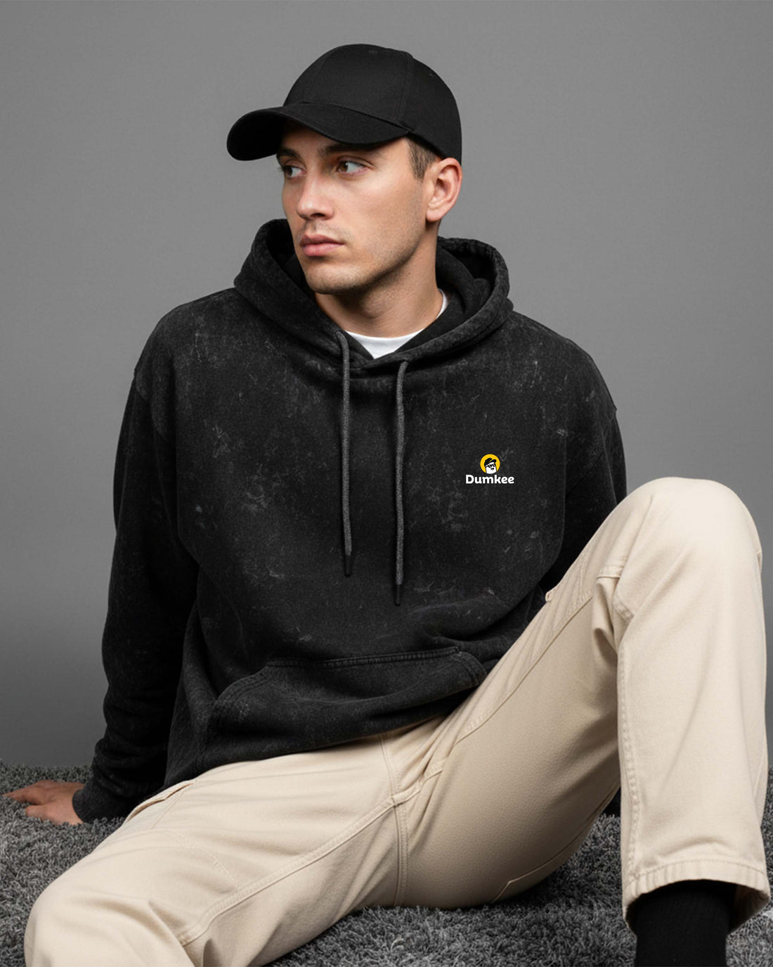 Man wearing a Dumkee Oversize black hoodie with a logo