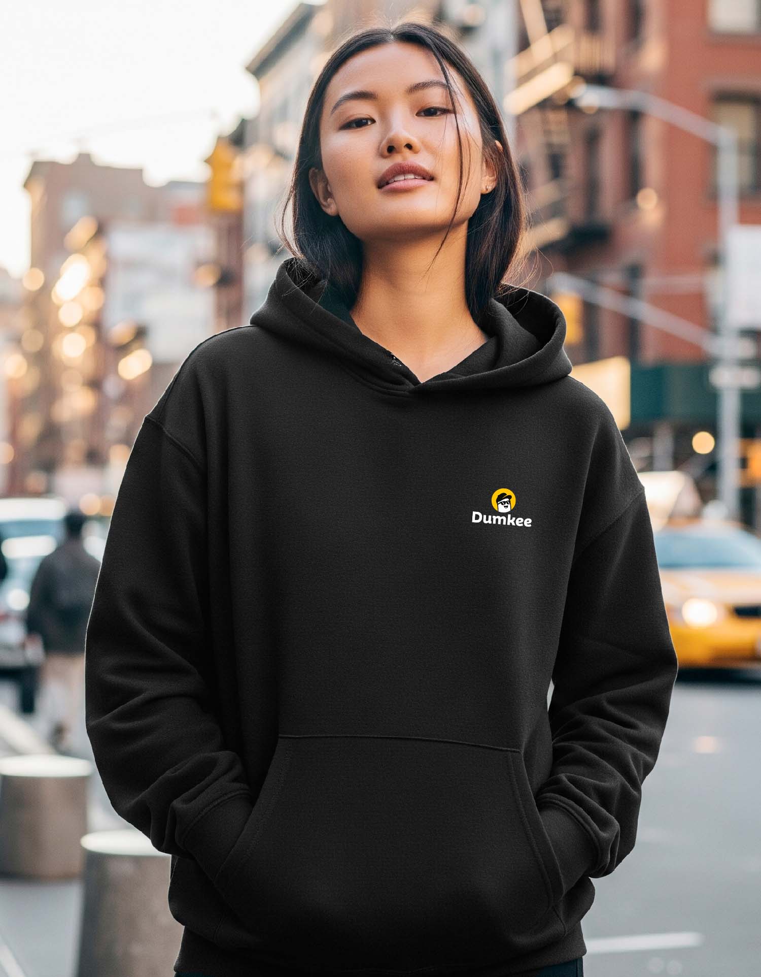 Person wearing a Dumkee  black hoodie with a Dumkee logo