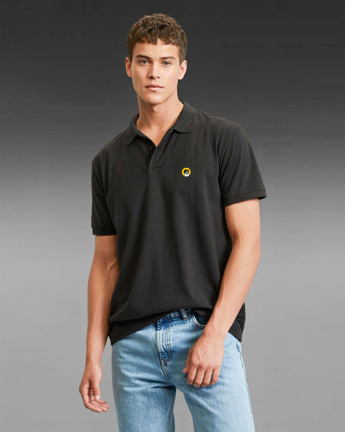 Man wearing a Dumkee black polo shirt with a yellow logo