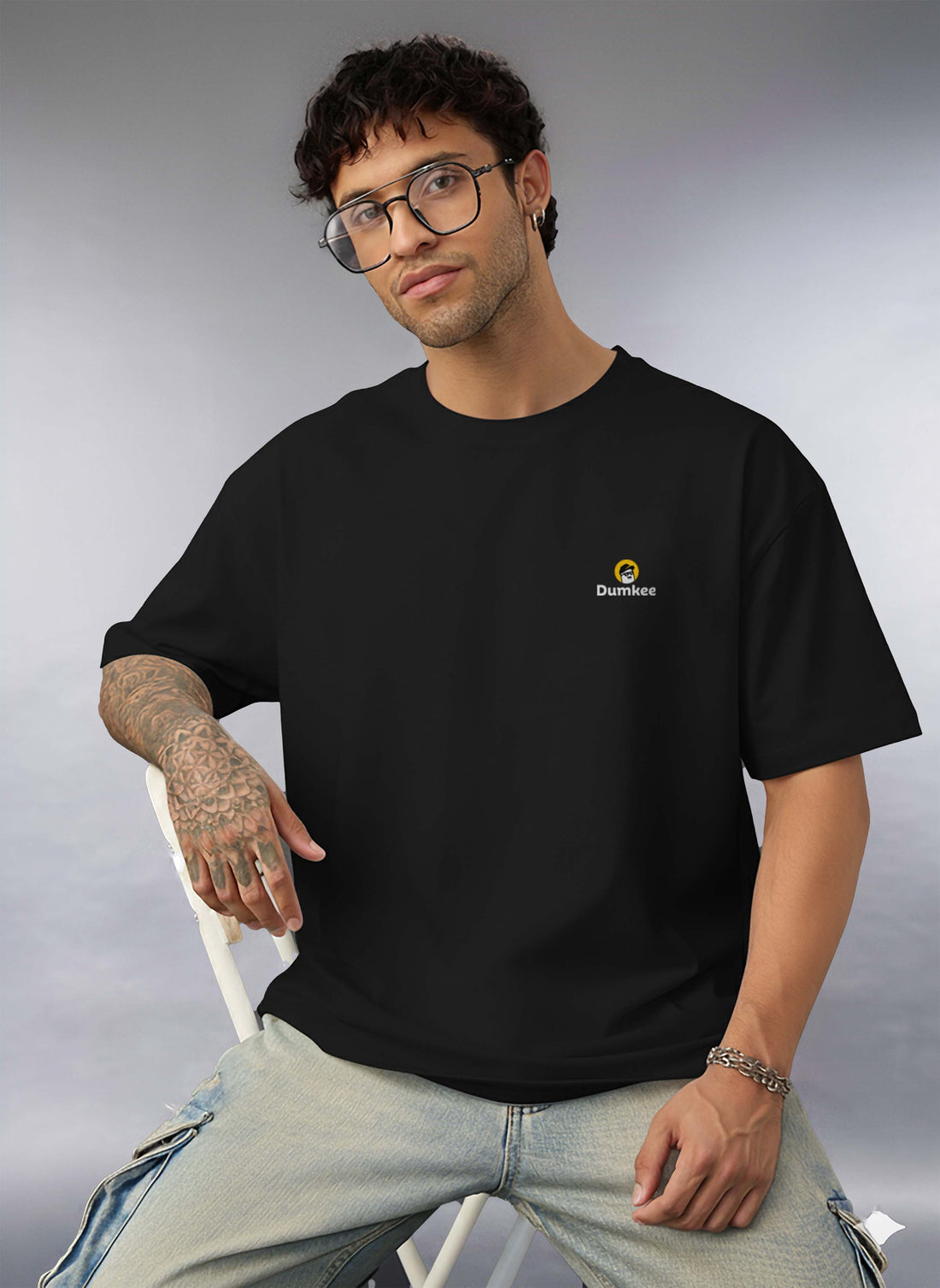 Man wearing a Dumkee Oversize black t-shirt with a logo