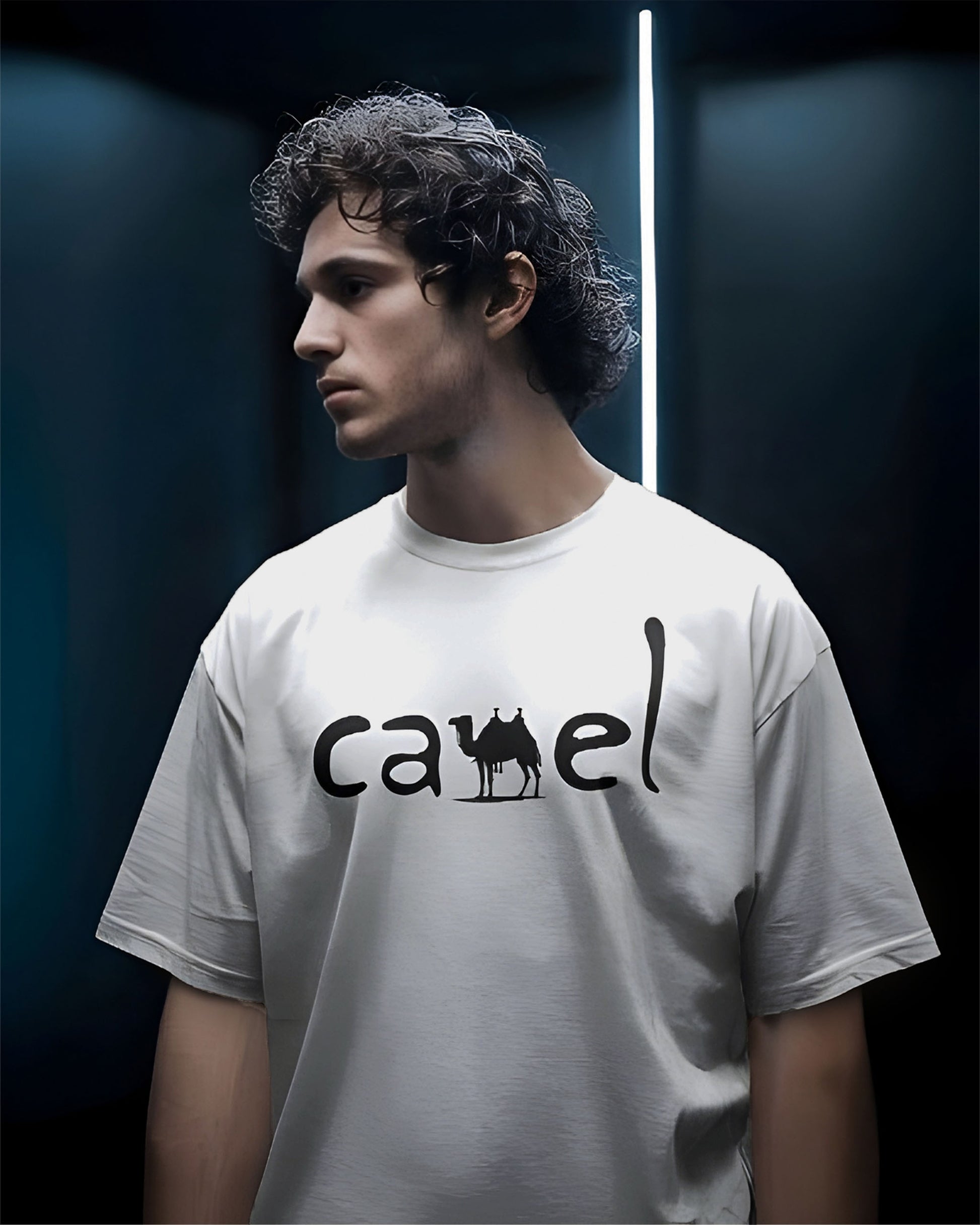Person wearing a Dumkee Oversize white t-shirt with 'camel' logo against a dark background