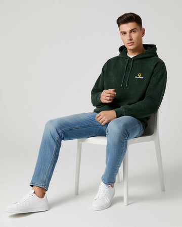 Man sitting on a Dumkee Oversize chair wearing a green hoodie