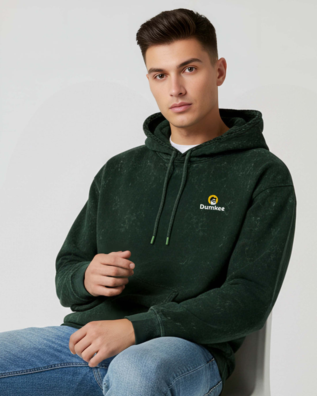 Man sitting on a Dumkee Oversize chair wearing a green hoodie
