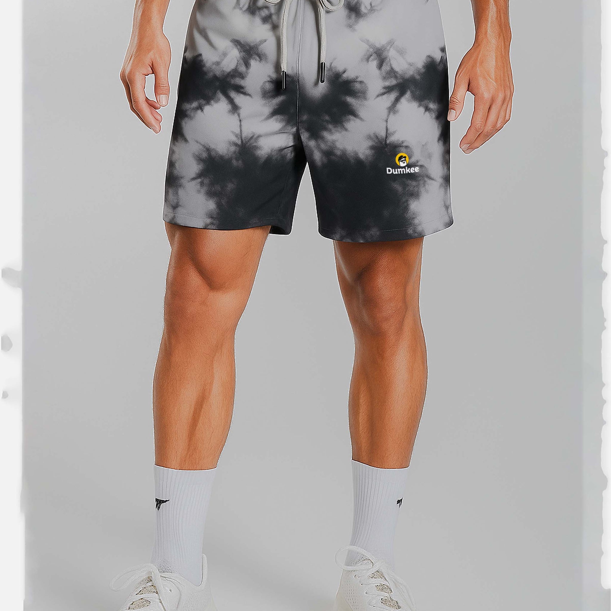 Person wearing Dumkee  tie-dye shorts with a brand logo on a plain background