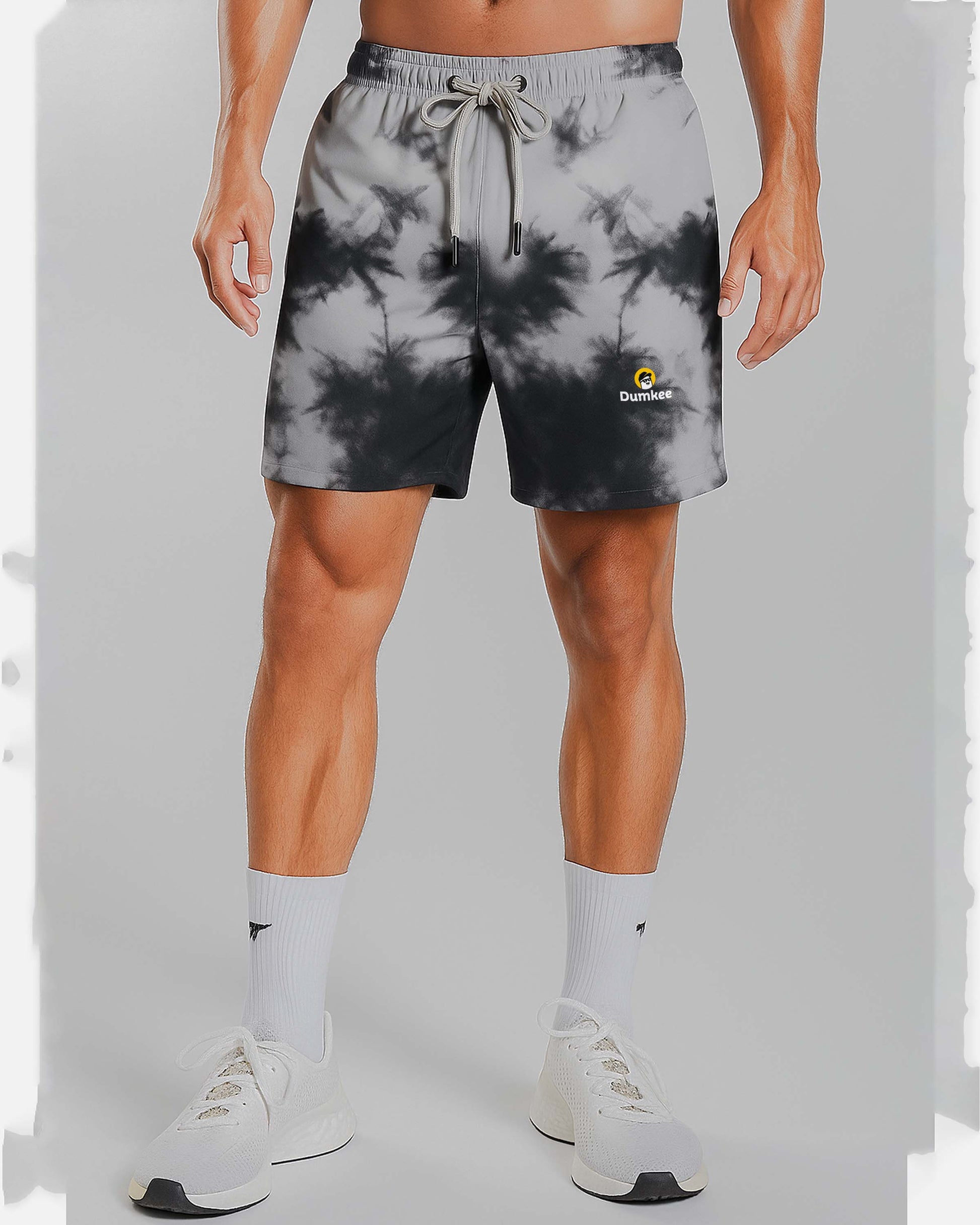 Person wearing Dumkee  tie-dye shorts with a brand logo on a plain background
