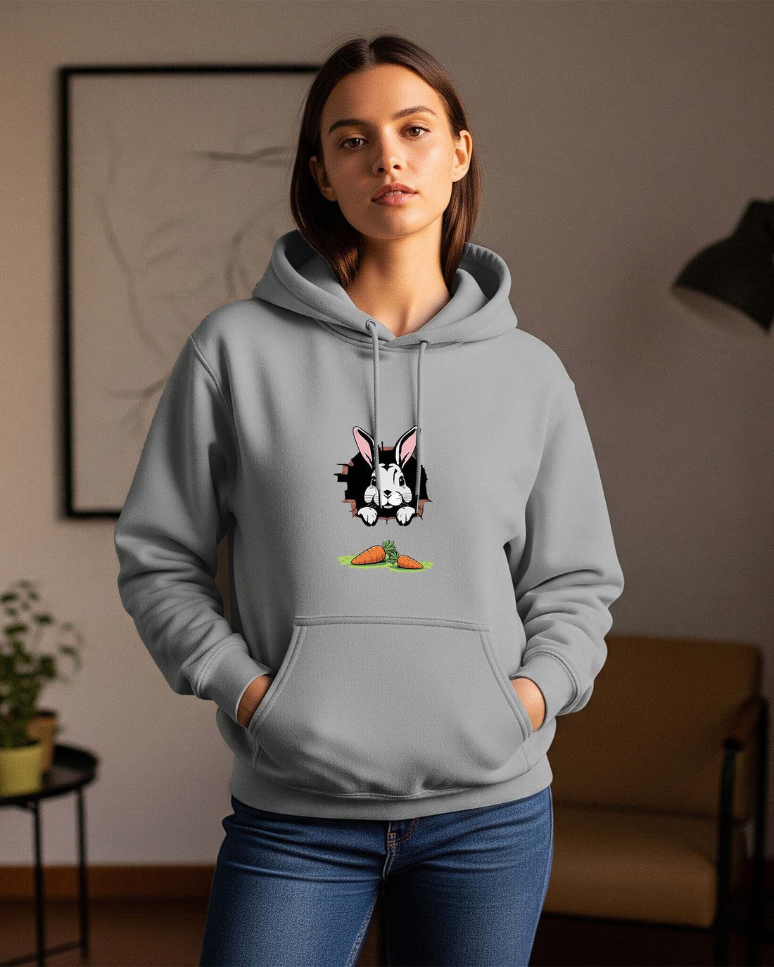 Women wearing a Dumkee gray hoodie with a rabbit character design in a room.