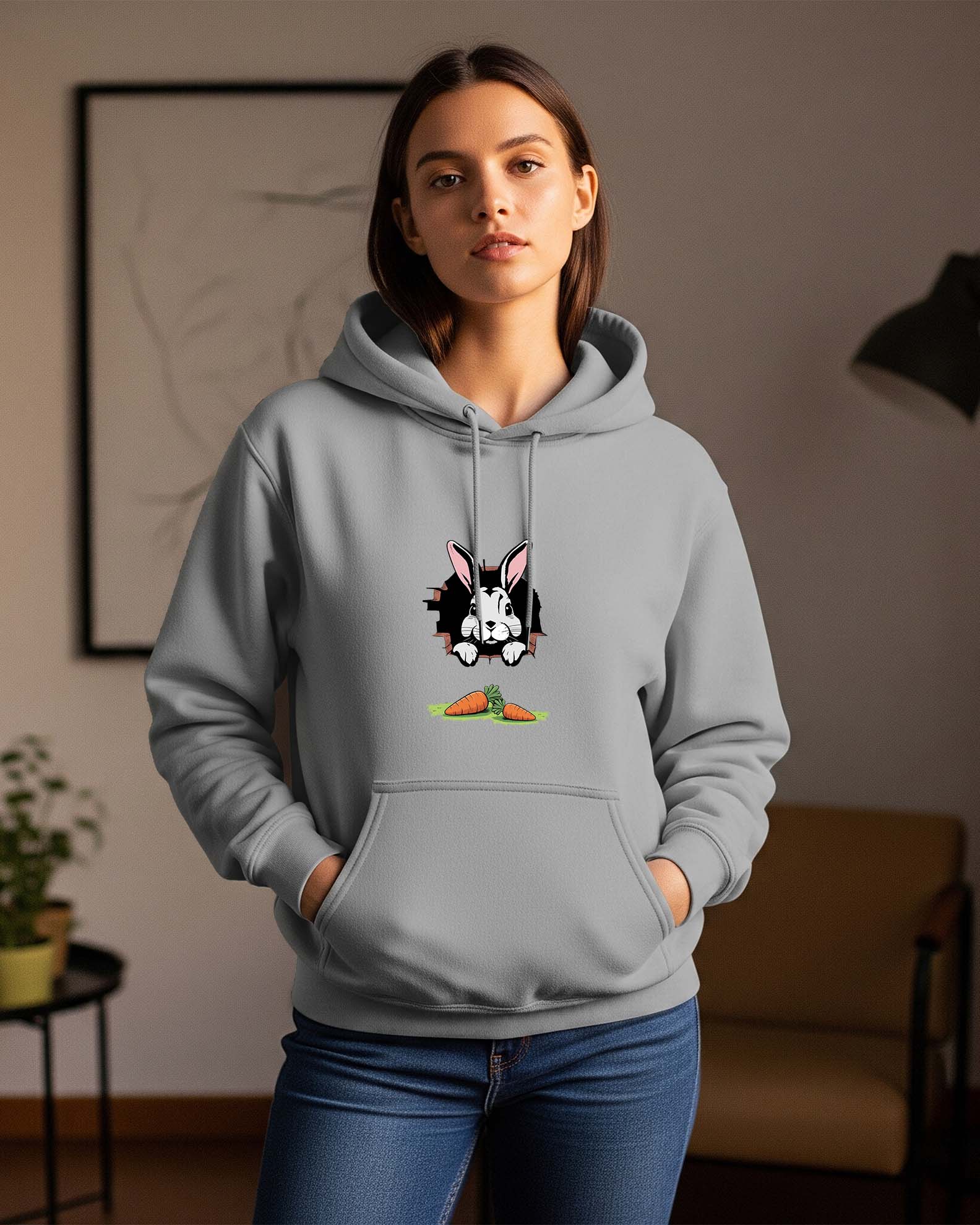 Women wearing a Dumkee gray hoodie with a rabbit character design in a room.