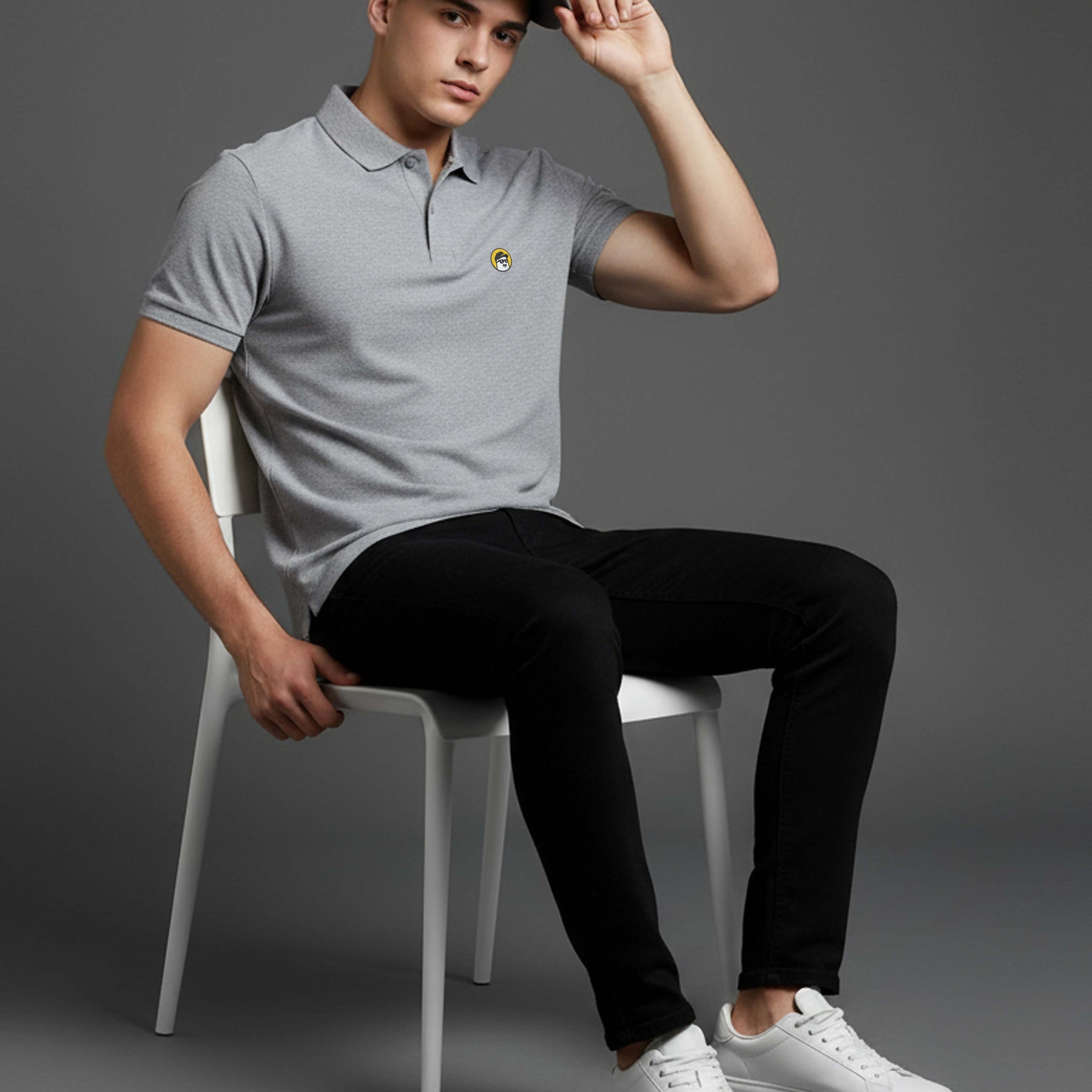 Man sitting on a chair wearing a Dumkee gray polo shirt