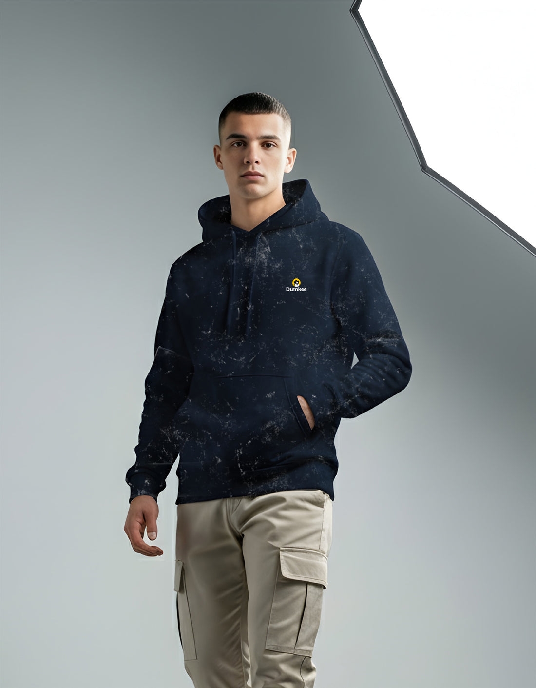 Man wearing a Dumkee Oversize dark blue hoodie with a logo on a gray background