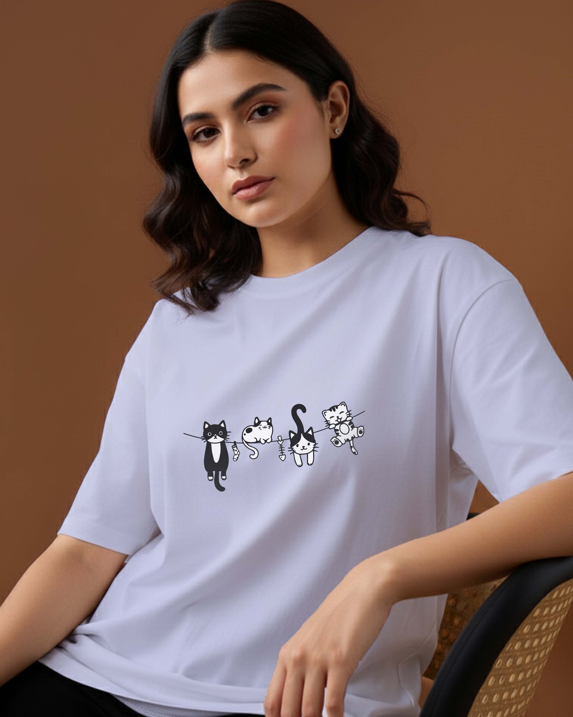 Woman wearing a Dumkee white  t-shirt with cat illustrations.