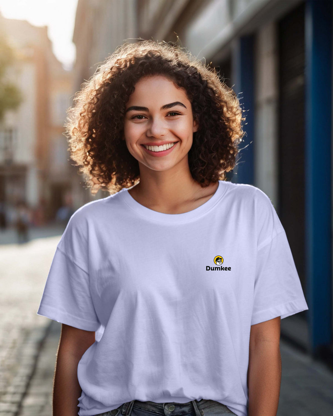 Person wearing a Dumkee Oversize white t-shirt with a Dumkee logo on a street.