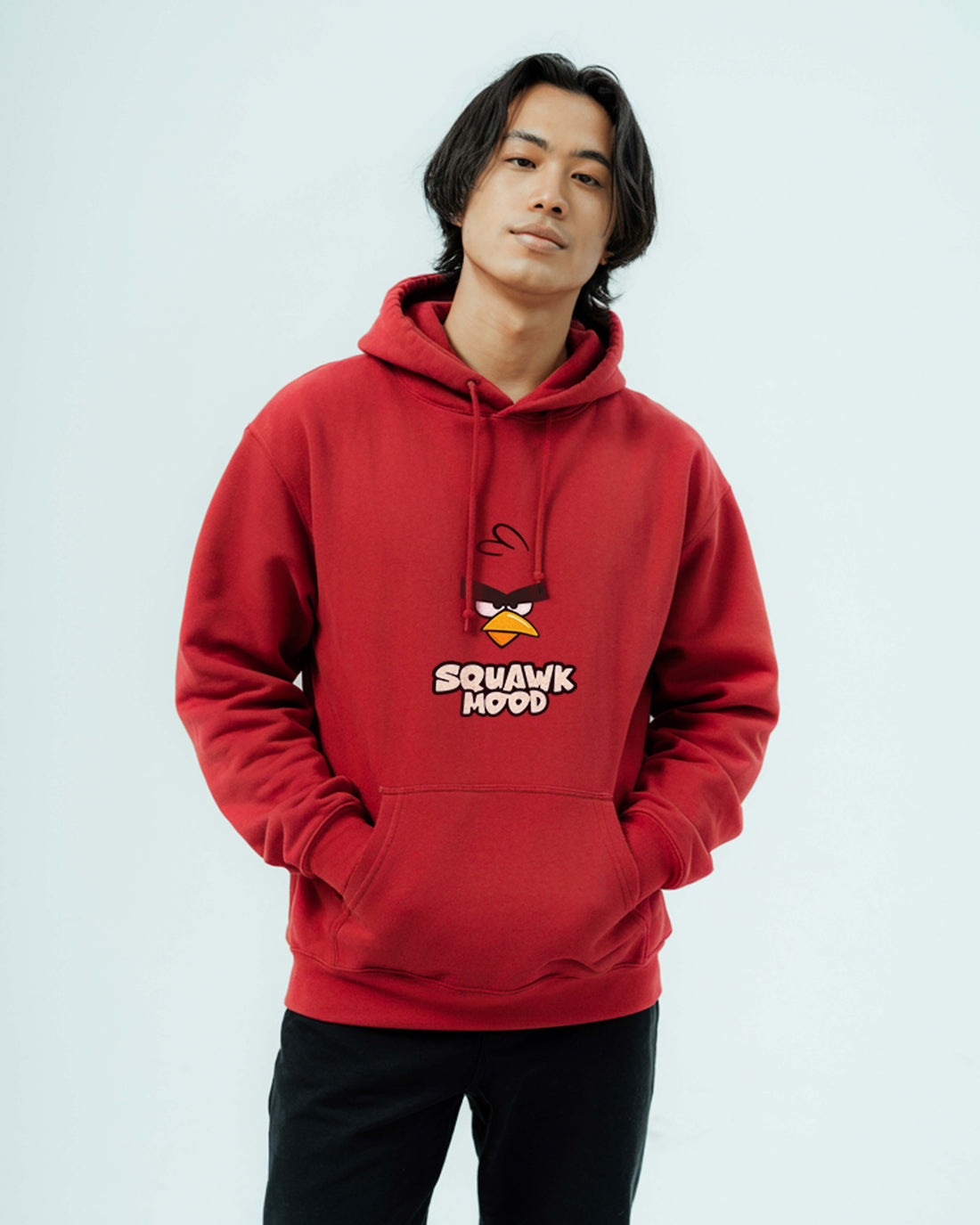 Person wearing a Dumkee red hoodie with an Angry Birds design on a light gray background
