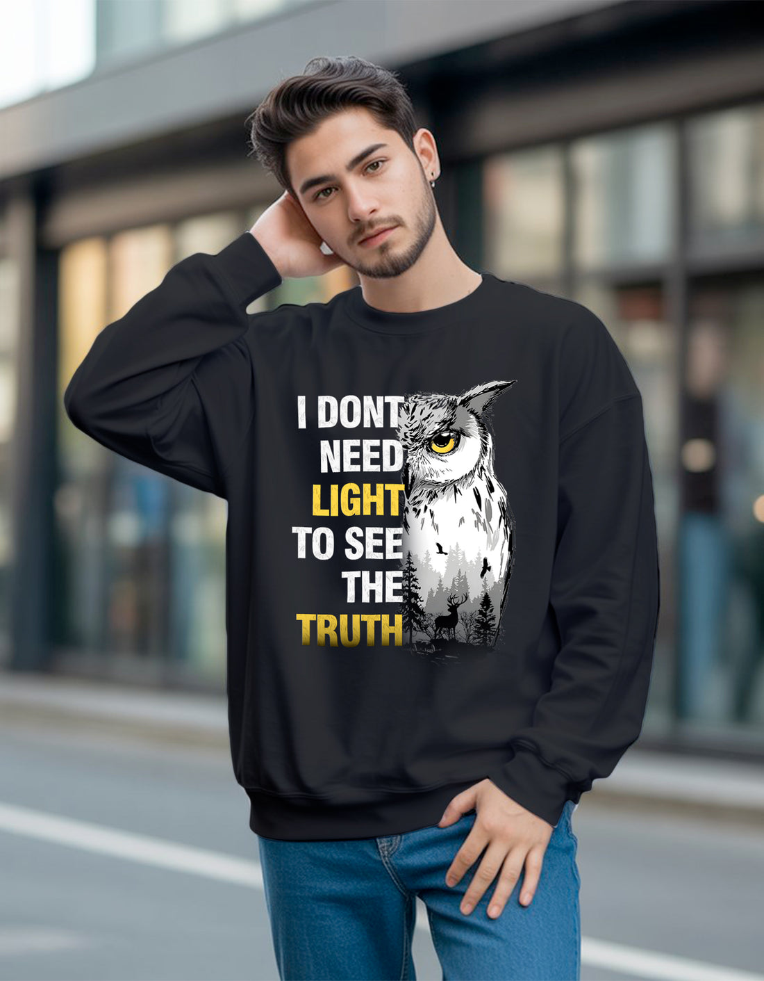 Man wearing a black Dumkee sweatshirt with an owl graphic and text on a blurred street background
