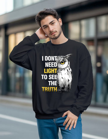 Man wearing a black Dumkee sweatshirt with an owl graphic and text on a blurred street background
