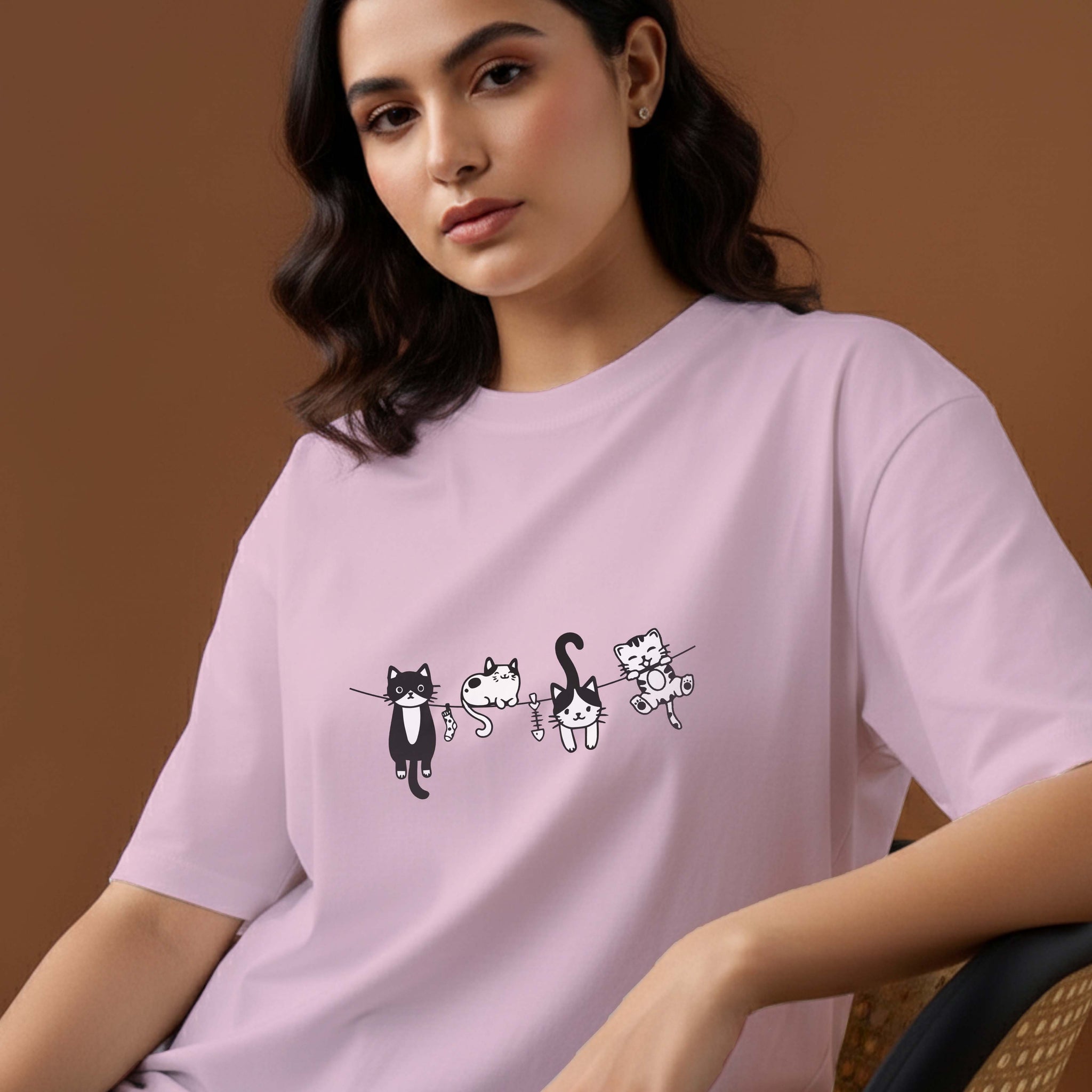 Woman wearing a Dumkee light purple oversize t-shirt with cat illustrations.
