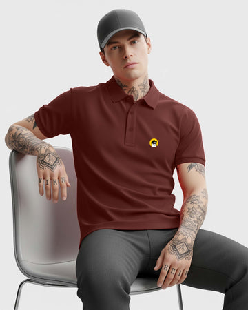 Man wearing a Dumkee brown polo shirt with a logo