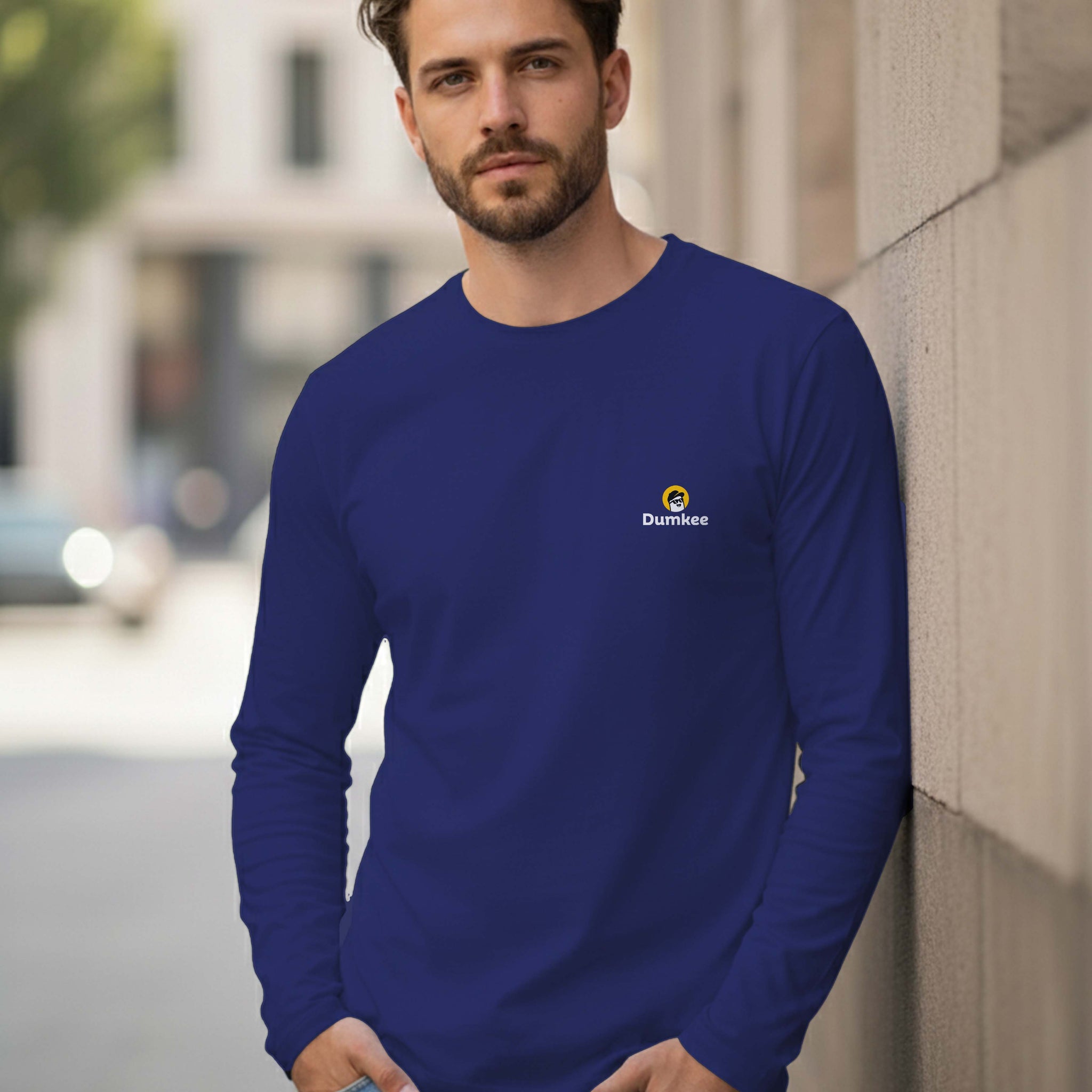 Man wearing a Dumkee blue long-sleeve shirt with a logo.