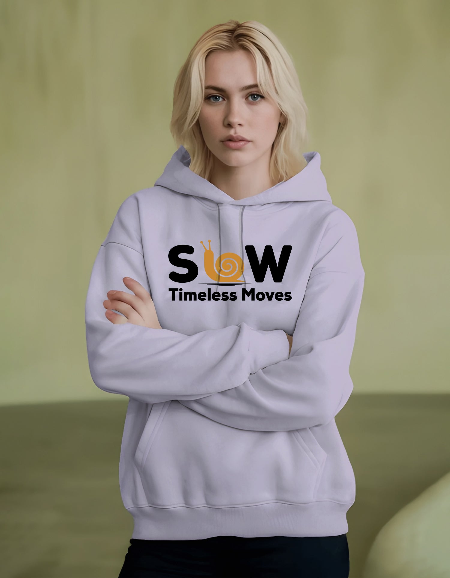 Person wearing a Dumkee light purple hoodie with 'SLOW Timeless Moves' text on a green background